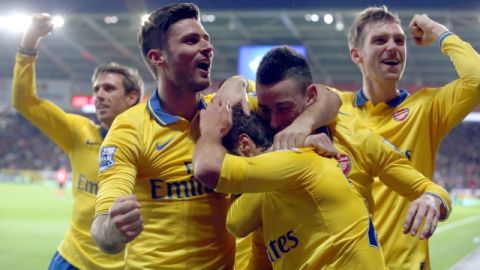 Jugadores del Arsenal rodean a  Mathieu Flamini, quien ayer   marcó el tercer tanto de su equipo ante el Cardiff.