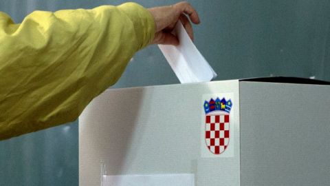 Un votante deposita su balota en una estación de votación, en Pula, al oeste de Croacia, ayer.