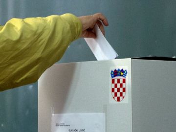 Un votante deposita su balota en una estación de votación, en Pula, al oeste de Croacia, ayer.