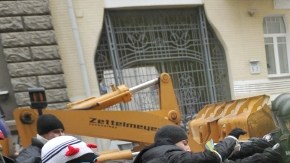 Manifestantes se resisten a la policía y tratan de pasar por encima de una barrera cerca del palacio presidencial, pidiendo la renuncia del Gobierno, ayer, en Kiev, Ucrania.