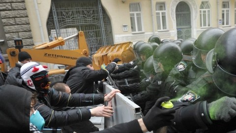 Manifestantes se resisten a la policía y tratan de pasar por encima de una barrera cerca del palacio presidencial, pidiendo la renuncia del Gobierno, ayer, en Kiev, Ucrania.
