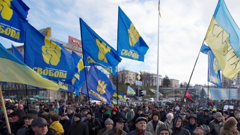 Los manifestantes ucranianos alzan banderas reunidos en la Plaza central de la Independencia, en Kiev.