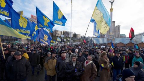 Los manifestantes ucranianos alzan banderas reunidos en la Plaza central de la Independencia, en Kiev.