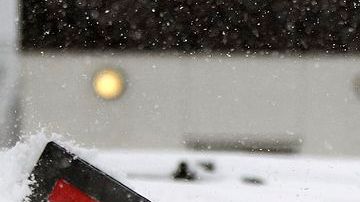 Hombres limpian autos que quedaron sepultados bajo la nieve en Brooklyn Center, en Minnesota.