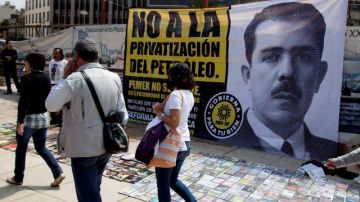 Personas caminan al lado de un cartel que muestra una imagen del ex presidente mexicano Lázaro Cárdenas, y que indica el sentir de una gran parte de la población mexicana.