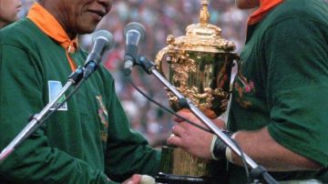 En junio 24 de 1995:  Nelson Mandela antrega a Francios Pienaar el trofeo de campeón de rugby.