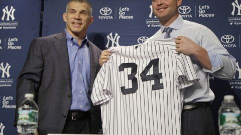 Brian McCann (der) muestra su camisola número 34 junto al mánager de los Yanquis, Joe Girardi.