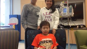 El niño Carlos Sedano, diagnosticado con leucemia, se entretiene con un juego de video junto a sus padres Juan Carlos Sedano y Blanca Villegas, en su habitación de hospital en Orange.