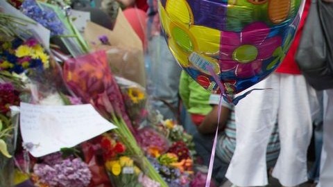 Una mujer enciende una vela en tributo al fallecido expresidente de Sudáfrica, Nelson Mandela, en el exterior de la que era la residencia del líder en Houghton.