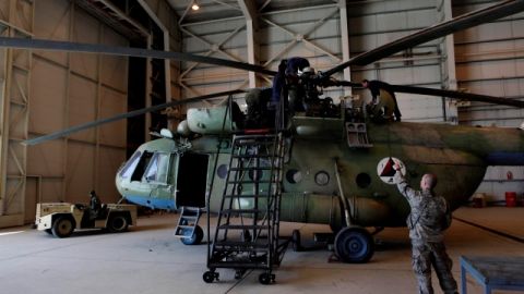 El sargento Troy Bencke (der.), de las Fuerzas Aéreas de EEUU,  señala hacia ingenieros afganos que trabajan en un Mi-17, en Kabul.