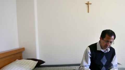 Luis Estrada, quien va a convertirse en sacerdote, lee en su cuarto del Seminario St. John en Camarillo, California.