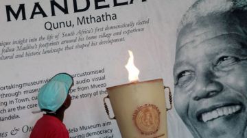 Un niño lee las palabras por encima de un retrato del expresidente Nelson Mandela, en el Museo Nelson Mandela en Qunu, Sudáfrica.