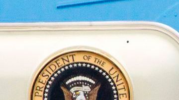 Barack Obama y su esposa Michelle abordaron el avión presidencial bajo un cielo lluvioso y frío para el largo viaje.