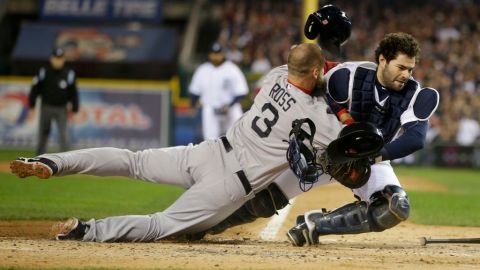 David Ross de los Boston Red Sox's choca en la registradora con el catcher de Detroit Alex Avila.