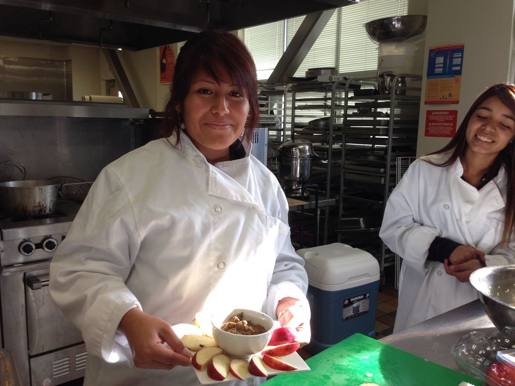Diana Gonzalez prepara su aperitivo de vegetales que ella misma cultivo durante el verano en la escuela. La acompana Maria Castro.