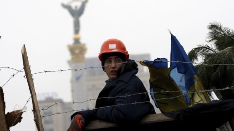 Un manifestante vigila una de las barricadas levantadas en el centro de Kiev. Ayer continuaban las protestas contra el Gobierno.