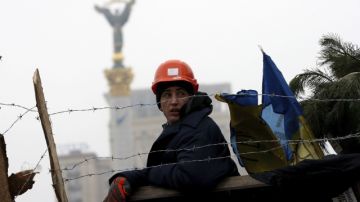 Un manifestante vigila una de las barricadas levantadas en el centro de Kiev. Ayer continuaban las protestas contra el Gobierno.
