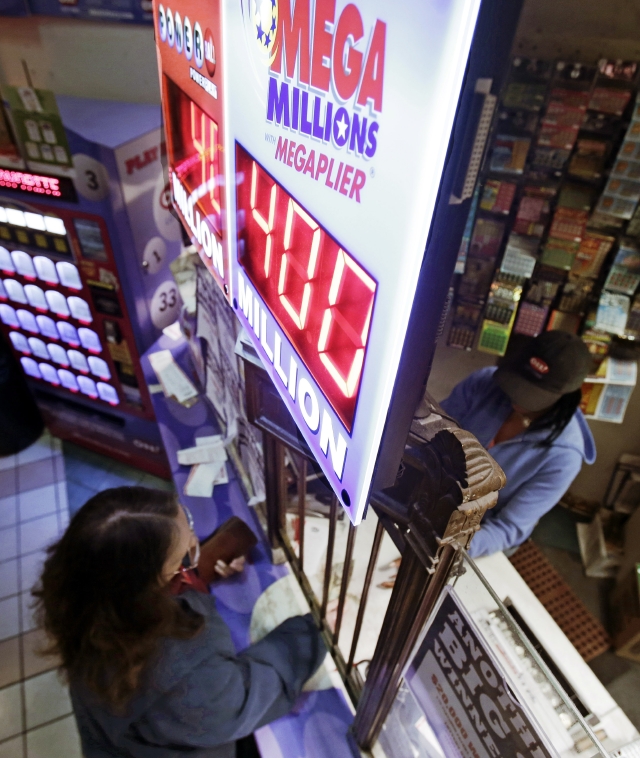 Una mujer compra un boleto para el sorteo de lotería   Mega Millions el jueves en Cleveland. No hubo ganador del premio mayor.