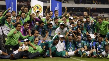 Los jugadores del León bromean mientras celebran con su copa de campeones en el césped del Estadio Azteca, tras derrotar al América en el juego de vuelta de la final del Apertura 2013.