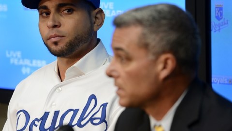 Omar Infante (izq.) escucha al gerente de Reales, Dayton Moore, quien habla en la conferencia de prensa.