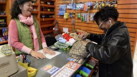 La dueña del establecimiento donde se vendió uno de los boletos ganadores de Mega Millions habla con una clienta en Atlanta.