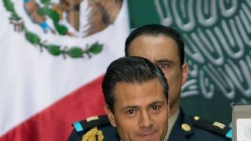El presidente de México, Enrique Peña Nieto muestra los documentos que firmó que promulgan las reforma energética en el Palacio Nacional en la Ciudad de México, el viernes, 20 de diciembre 2013.