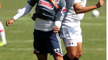 El delantero de Chivas,  Jesús 'Chapo' Sánchez (izq.), le gana  el balón por arriba a un jugador del San Luis.