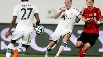 Franck Ribery (c), del Bayer Munich, supera la marca de Zhang Linpeng (d), del equipo chino Guangzhou Evergrande, en el partido semifinal del Mundial de Clubes.