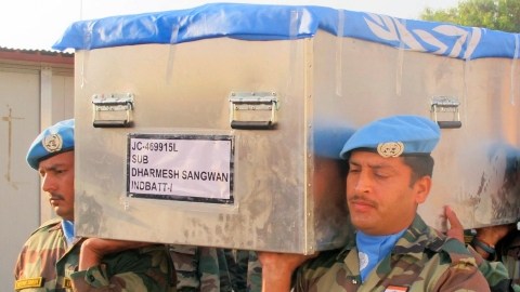 Miembros de la Fuerza de Paz  cargan un ataúd con los restos de un colega, víctima de  disturbios en el convulsionado país.