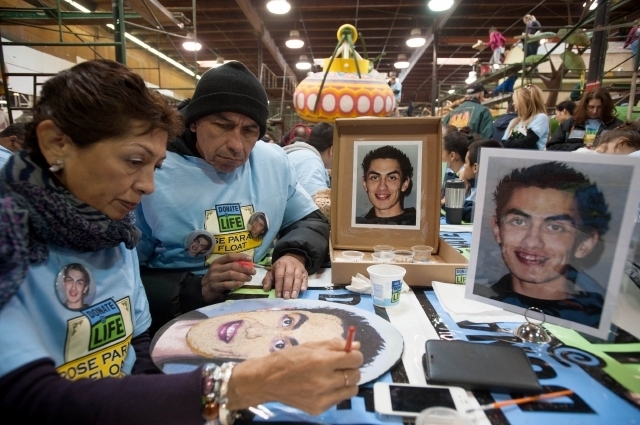 Patricia Escobedo y su esposo, Carlos García, decoran la imagen de su hijo, Carlos García, que será adherida a la Carroza de Done Vida.