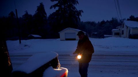 Jim Ridley usa una linterna pararecoger su correo, en Litchfield, Maine, donde ha estado sin electricidad desde la tormenta de hielo del lunes.