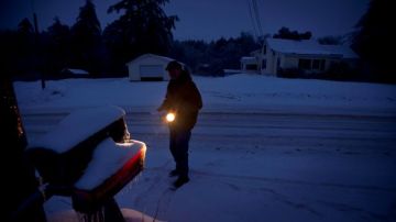 Jim Ridley usa una linterna pararecoger su correo, en Litchfield, Maine, donde ha estado sin electricidad desde la tormenta de hielo del lunes.