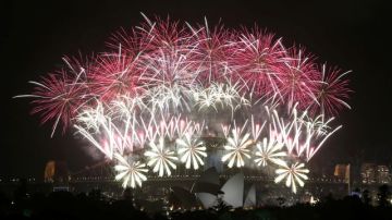 Fuegos artificiales estallan sobre Harbour Bridge y el teatro de la Ópera durante las celebraciones de Año Nuevo en Sídney, Australia.