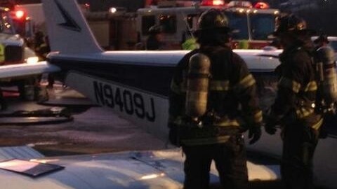 Bomberos junto a la avioneta que aterrizó en una autopista de Nueva York.