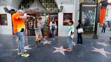 Turistas se toman fotos en el conocido Paseo de la Fama de Hollywood.