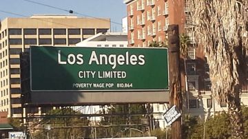 El cartel anuncia: “Los Ángeles Ciudad Limitada, Población con Salario de Pobreza 810,864” (City Limited Poverty Wage Pop 810,864).