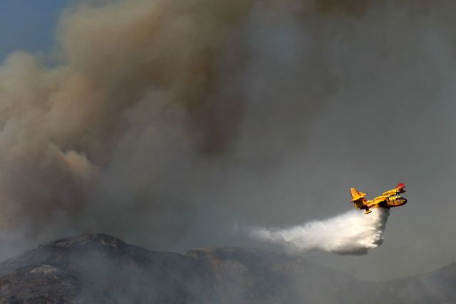 En esta foto del jueves, 16 de enero, se ve un avión de extinción de incendios lanzando agua en las colinas de Glendora, abrumadas por las llamas.