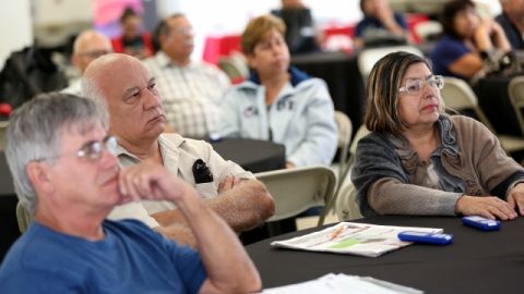 Personas interesadas en obtener un nuevo seguro médico escuchan sobre las diferentes opciones, durante unl foro comunitario.
