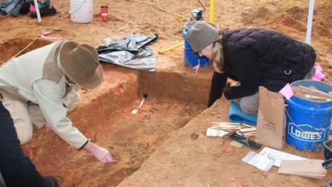El estudiante de USF  y la doctora Jennifer Mack del Equipo de Respuesta de Investigaciones Forenses de Florida  trabajan en la recuperación de restos en un cementerio de un antiguo reformatorio público.