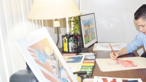Jiovanny López en su mesa de trabajo dando los últimos toques a uno de sus dibujos.