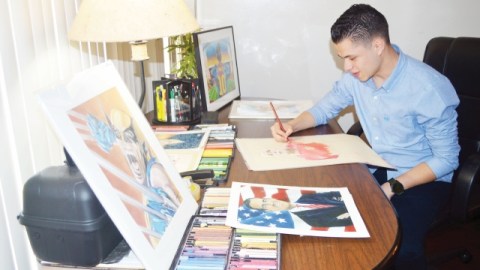 Jiovanny López en su mesa de trabajo dando los últimos toques a uno de sus dibujos.
