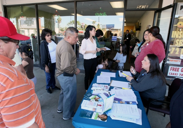 Personas sin seguro reciben información sobre Obamacare en Los Ángeles.