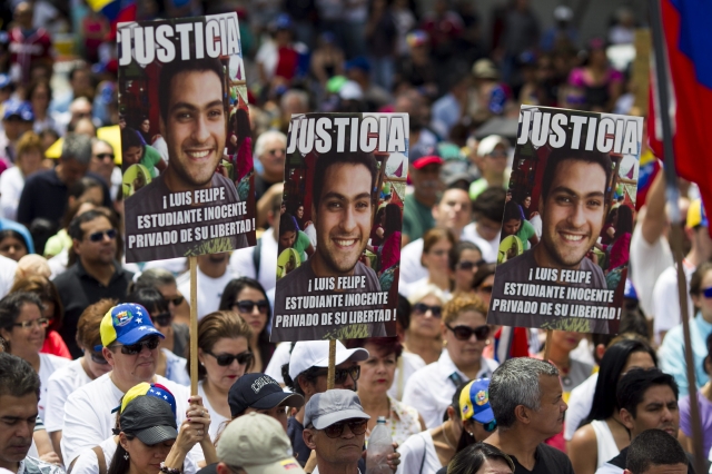 Manifestantes se concentraban en una plaza con pancartas, ayer, para protestar contra el Gobierno de Nicolás Maduro, en Caracas.