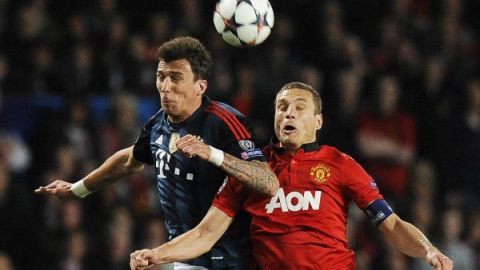 Mario Mandzukic (i) del Bayern Munich en acción ante Nemanja Vidic (d) del Manchester United