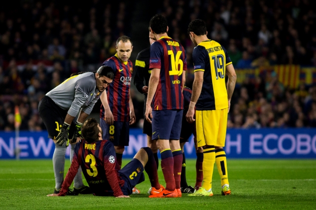 Gerard Piqué yace en el césped luego de lastimarse la cadera en el duelo entre culés y 'colchoneros en la Liga de Campeones.