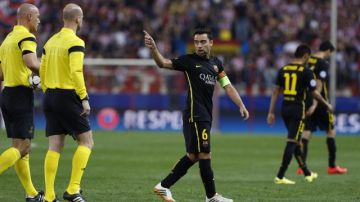 El capitán del  Barcelona Xavi Hernández (der.) se va disgustado con los árbitros tras la derrota 1-0 ante el Atlético.