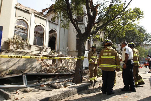 Bomberos inspeccionan el derrumbe de una barda y parte de la estructura de una casa antigua que permanecía habitada por personas sin hogar en la colonia Juárez después de que un movimiento sísmico se sintió hoy, viernes 18 de abril de 2014, en la Ciudad de México.