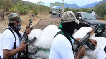 Un grupo de autodefensas vigila el acceso a  Churumuco, Michoacán (México), debido a la constante violencia en ese estado mexicano que ha hecho que los mismos pobladores tomen las armas.