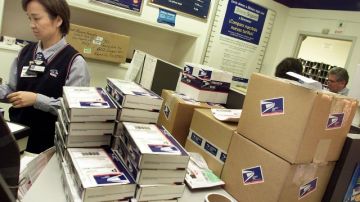 Un trabajador en una oficina de Correos de Lincoln Heights, en Los Ángeles. Para frenar una crisis económica. el Servicio Postal (USPS) ha cerrado y hasta vendido algunas de sus oficinas en todo el país.