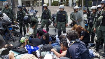 Manifestantes opositores al Gobierno de Nicolás Maduro son retenidos por la Guardia Nacional Bolivariana (GNB), en Caracas, Venezuela.